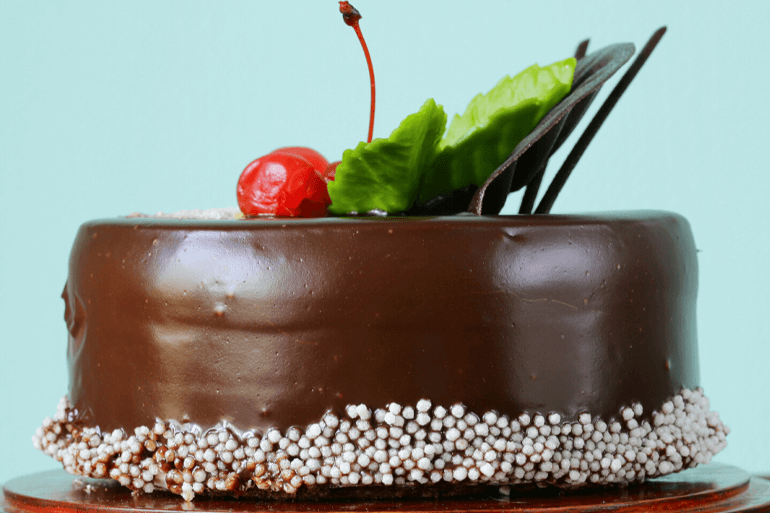 Chocolate Celebration cake topped with cherry