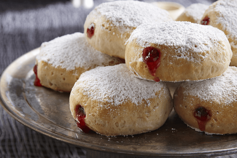 powdered sugar coated donuts with raspberry filling