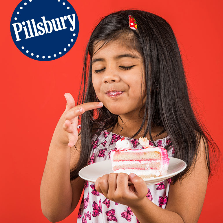 Girl licking pillsbury cream cake from plate