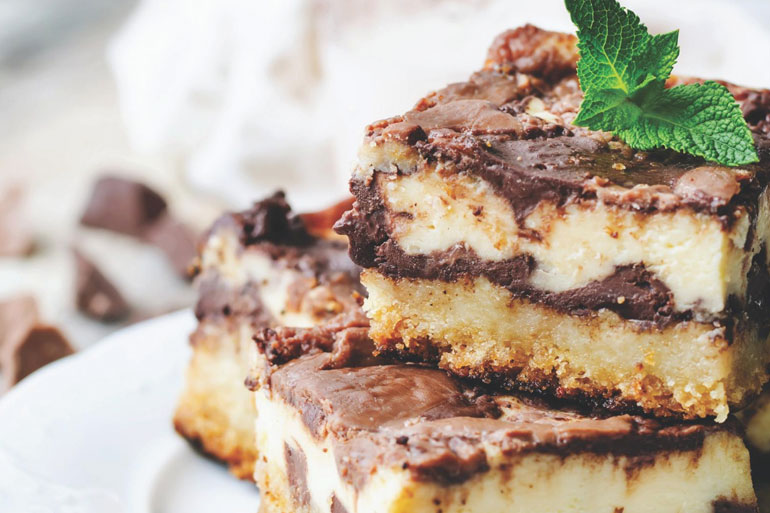 CheeseCake Brownie Bars garnished with mint leave