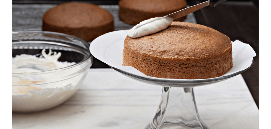 adding frosting to spong cake