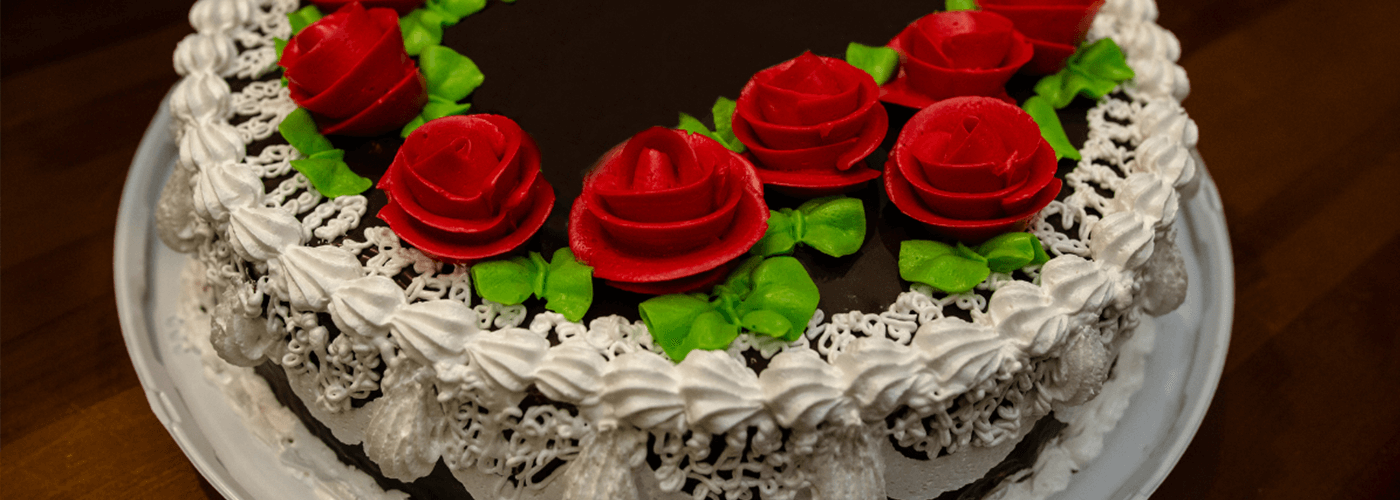 A whole frosted decorated cake with fondant roses