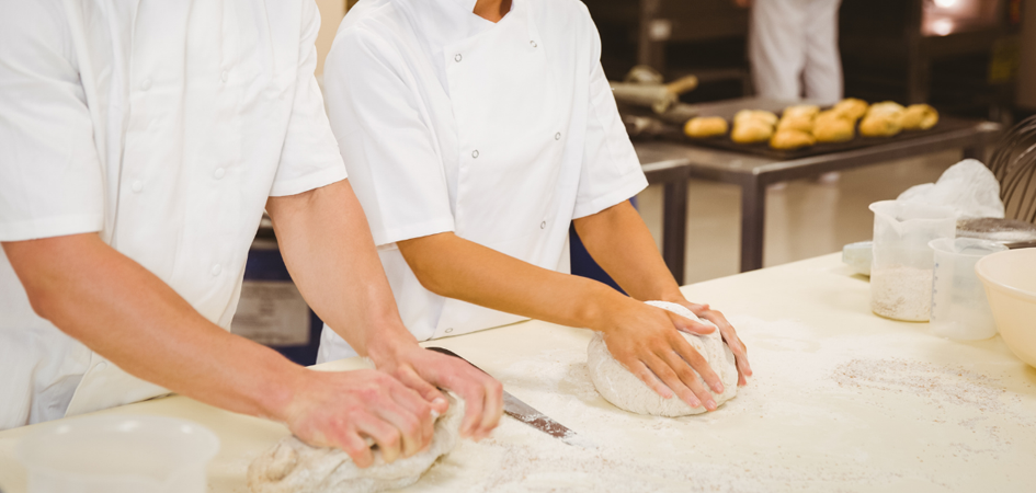 two chefs kneding dough